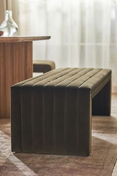 a bench sitting on top of a rug next to a table