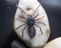 Add a touch of spooky elegance to your look with this handmade spider necklace. The pendant, made of copper, features a spider shape with a beautiful labradorite stone and abalone shell. The necklace is perfect for Halloween or any day, and its unique design is sure to make you stand out. The necklace is unisex and comes with a lobster clasp closure. Get this one-of-a-kind spider necklace today and elevate your jewellery collection. Handmade necklace Unique one of a kind item. This statement spider pendant is created from  labradorite and abalone shell cabochons, wrapped in antiqued bare copper wire. The purity of the copper exceeds 99.97%. Supplied with 18 inch antique copper effect metal chain necklace with lobster clasp fastening. Lore of the Inuit peoples claim Labradorite fell from th Wire Wrapped Spider, Healing Crystals Meanings, Spider Necklace, Psychic Development, Les Chakras, Jewellery Ideas, Necklace Unique, Crystal Meanings, Labradorite Stone