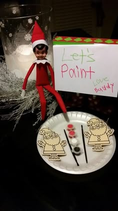 an elf is sitting on top of a paper plate with some candy in front of it