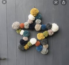 multicolored knitted snowflake hanging on the side of a building