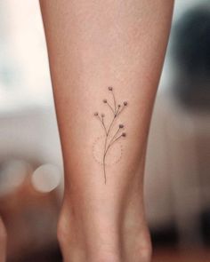 a woman's foot with a small flower tattoo on her left side calfocks