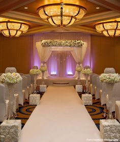 a wedding ceremony setup with white flowers on the aisle