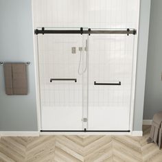 a bathroom with a shower, toilet and bathtub next to a chevron wood floor