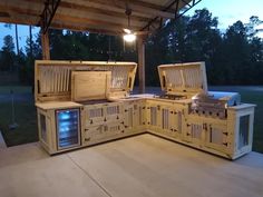 an outdoor kitchen made out of wood with grills and drawers on the outside wall