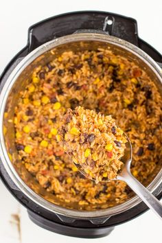 a spoon full of rice and beans in an instant pressure cooker with the lid open