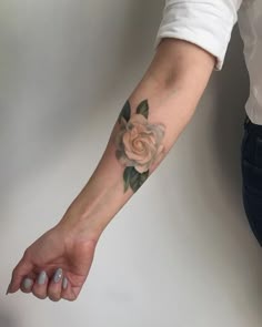 a woman's arm with a rose tattoo on it