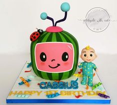 there is a cake that looks like a tv with a face on it and a ladybug figurine next to it