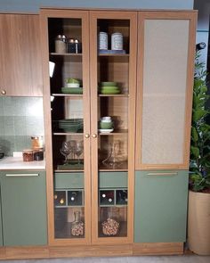 a green cabinet with glass doors in a kitchen