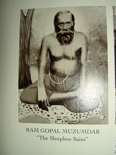 an old black and white photo of a man with a beard sitting in front of a tree