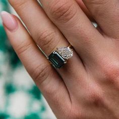 a close up of a person's hand with a diamond ring on their finger