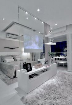 a bedroom with a large screen on the wall