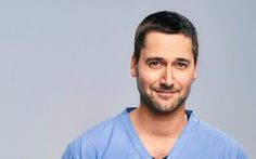 a man in scrubs is smiling at the camera