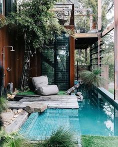 a backyard with a swimming pool surrounded by greenery