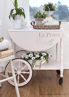 a white cart with flowers and plants on it