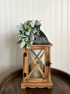 a small wooden lantern with succulents on top