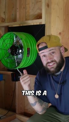 a man holding a green fan in his right hand and pointing it at the camera