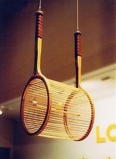 two tennis racquets hanging from strings on a wall