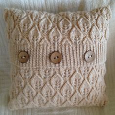 a knitted pillow with buttons on it