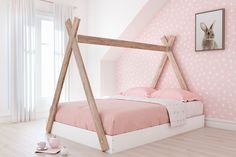 a bedroom with pink wallpaper and white bedding has a wooden frame for the headboard