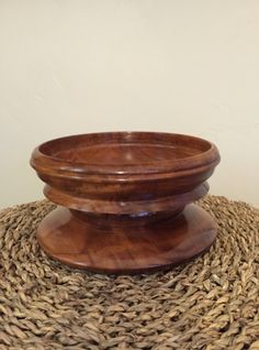 a wooden bowl sitting on top of a straw mat