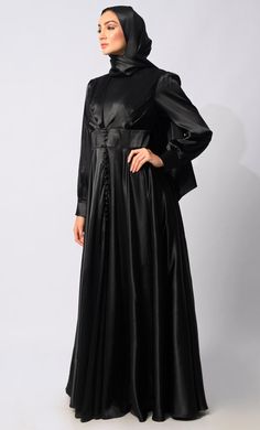 Introducing our exquisite Lycra Satin Flared Abaya, a stunning fusion of elegance and contemporary style. Crafted with meticulous attention to detail, this abaya is designed to elevate your modest fashion wardrobe to new heights. The flared silhouette adds a touch of graceful movement, enhancing the overall allure of the garment. Featuring a front draped pleated style, which adds texture and dimension, creating visual interest and a unique focal point. Complementing the pleats are satin show buttons, delicately embellishing the front of the abaya for a refined finish. For added versatility and cinched-in definition, an attached belt accompanies the abaya, allowing you to adjust the fit according to your preference and accentuate your waistline. The back zipper closure ensures a seamless an Graceful Movement, Abayas Fashion, Black Satin, Modest Fashion, Focal Point, Contemporary Style, Satin, Couture, Wardrobe