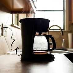 a black coffee maker sitting on top of a counter