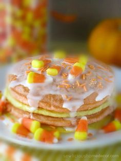 a stack of pancakes covered in frosting and candy corn on top of a plate