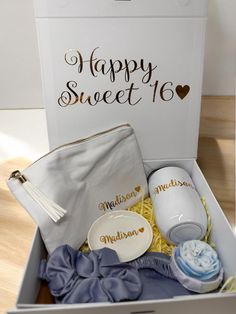 a white box filled with personal items and a happy sweet 16 sign