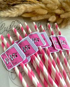 pink and white striped paper straws are lined up on top of each other,