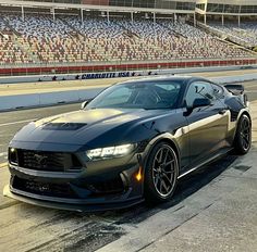 a black sports car driving down a race track