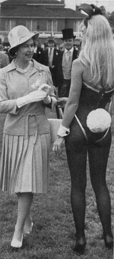 an old photo of two women standing next to each other in front of a crowd