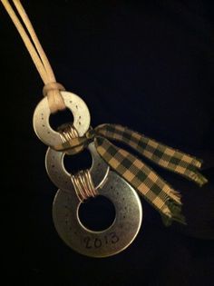 three metal objects hanging from a string on a black background