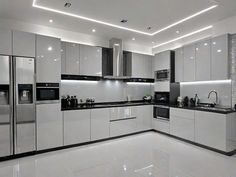 a modern kitchen with white cabinets and black counter tops, along with stainless steel appliances