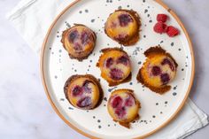 small pastries on a plate with raspberries