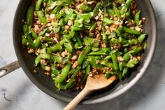 a skillet filled with green beans and nuts