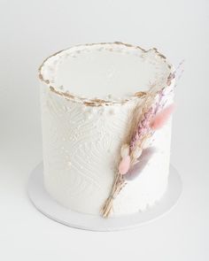 a close up of a cake on a plate with flowers and feathers in the middle