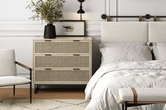 a bedroom with white linens and neutral decor, including an upholstered bed