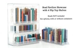 a clear plastic book shelf with 4 flip top shelves filled with books and other items