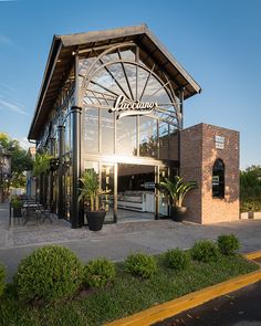 the outside of a restaurant with an awning over it's entrance and patio area