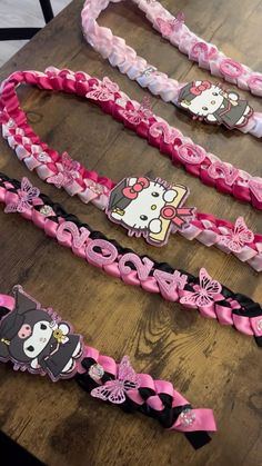 four hello kitty headbands sitting on top of a wooden table