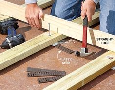 a man is working on some wood with hammers and screwdrivers in his hand