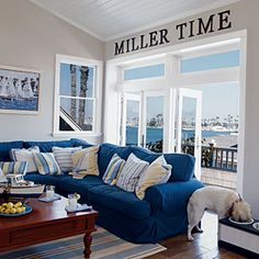 a living room filled with furniture and a dog eating out of a bowl on the floor