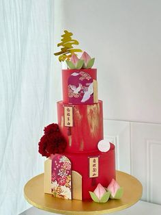 a three tiered red cake with flowers on it's side and chinese writing on the top