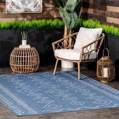 a blue rug with white writing on it next to a chair and potted plant