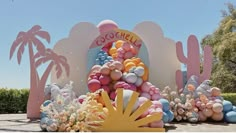 there is a giant balloon arch in the shape of a cactus with balloons all over it