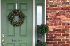 a green door with a welcome sign on it