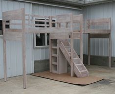 a wooden bunk bed with stairs next to a building