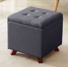 a gray ottoman sitting on top of a rug