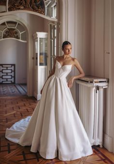 a woman in a white wedding dress posing for the camera