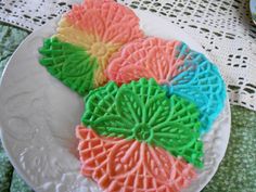 three decorated cookies sitting on top of a white plate